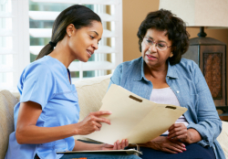 nurse showing medical records to a senior woman