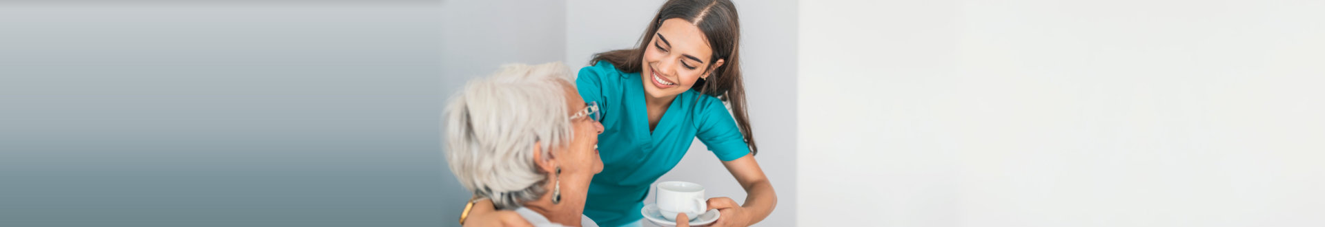 caregiver giving senior woman a cup of tea